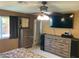 Comfortable main bedroom featuring a ceiling fan, TV and dresser, perfect for relaxation at 5821 Santa Catalina Ave, Las Vegas, NV 89108