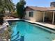 Sparkling pool with blue tiled trim, surrounded by trees and a concrete patio at 5821 Santa Catalina Ave, Las Vegas, NV 89108
