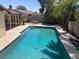 Inviting in-ground pool, lush landscaping, and adjacent covered patio offers relaxing outdoor space at 5821 Santa Catalina Ave, Las Vegas, NV 89108
