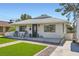 Attractive one-story home featuring a well-kept lawn and a cozy front porch with chairs at 615 D Ave, Boulder City, NV 89005