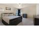A calm bedroom with a dark bed frame, soft carpet, and desk area by the window at 6217 Lapilli Ave, Las Vegas, NV 89139