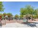 Outdoor playground area with swings, slides, and shaded seating areas for residents at 6217 Lapilli Ave, Las Vegas, NV 89139