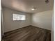 A bright bedroom showcasing wood-look floors, base moldings and a single window at 6905 Singing Dunes Ln, Las Vegas, NV 89145