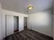 This bedroom features wood flooring, neutral paint, a sliding door closet and ample lighting at 6905 Singing Dunes Ln, Las Vegas, NV 89145