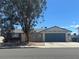 Charming single-story home featuring a two-car garage, a lush tree in the front yard, and a blue and beige color scheme at 6905 Singing Dunes Ln, Las Vegas, NV 89145