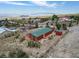 Quaint red home exhibiting its green roof, a detached shed, and a partially fenced, expansive yard at 70 Camp Bonanza Rd, Las Vegas, NV 89124