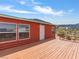 Exterior view of a red home showcasing a spacious wooden deck at 70 Camp Bonanza Rd, Las Vegas, NV 89124