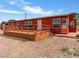 A red home featuring a spacious wooden deck and desert landscaping at 70 Camp Bonanza Rd, Las Vegas, NV 89124