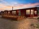 A red home featuring a spacious wooden deck and desert landscaping at 70 Camp Bonanza Rd, Las Vegas, NV 89124