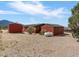 Exterior view shows a red cabin, garage, propane tank, and desert landscape at 70 Camp Bonanza Rd, Las Vegas, NV 89124