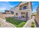 Spacious backyard with artificial grass, a patio area, and a built-in barbecue grill at 7107 Tilligerry St, North Las Vegas, NV 89084