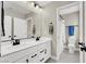 Well-lit bathroom with double sinks, white cabinets, and a separate toilet and shower area at 7107 Tilligerry St, North Las Vegas, NV 89084
