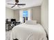 Bright bedroom with a large window, ceiling fan, and a functional workspace for studying or working at 7107 Tilligerry St, North Las Vegas, NV 89084