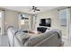 Cozy living room with comfortable sectional sofa, large windows, and a modern ceiling fan at 7107 Tilligerry St, North Las Vegas, NV 89084