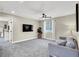Bright living room with plush carpet, ceiling fan, and a modern media center for entertaining at 7107 Tilligerry St, North Las Vegas, NV 89084