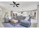 Spacious living area with comfortable sectional, modern decor, and open kitchen layout at 7107 Tilligerry St, North Las Vegas, NV 89084