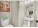 Stylish powder room featuring a pedestal sink, round mirror, and tasteful decor at 7107 Tilligerry St, North Las Vegas, NV 89084