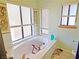 Bright bathroom featuring a soaking tub surrounded by windows, enhanced by natural light and a tile floor at 731 W Calvada Blvd, Pahrump, NV 89048