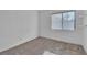 A minimalist bedroom with a large window and tan carpet flooring at 765 Butternut Ct, Henderson, NV 89014