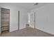 Spare bedroom featuring tan carpet, closet with storage shelving, and neutral walls at 765 Butternut Ct, Henderson, NV 89014