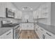 Updated kitchen featuring white cabinets, stainless steel appliances, and modern gray countertops at 765 Butternut Ct, Henderson, NV 89014