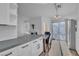 Bright kitchen with gray quartz countertops, white cabinetry, stainless steel appliances, and access to the patio at 765 Butternut Ct, Henderson, NV 89014