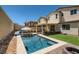 Backyard view showcasing a modern pool, artificial grass and a covered patio for outdoor relaxation at 7761 Sagamore Bay Ct, Las Vegas, NV 89179