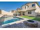 Backyard featuring a pool, fire pit, synthetic grass and patio for relaxing at 7761 Sagamore Bay Ct, Las Vegas, NV 89179