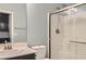 Bathroom featuring a shower with glass doors, neutral paint, and black cabinets at 7761 Sagamore Bay Ct, Las Vegas, NV 89179