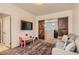 Inviting bonus room with rustic sliding doors, gray sofa, and wall-mounted TV at 7761 Sagamore Bay Ct, Las Vegas, NV 89179