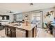 Spacious kitchen island featuring a double sink, dishwasher, and a view of the backyard pool area at 7761 Sagamore Bay Ct, Las Vegas, NV 89179