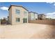 Backyard view showing houses with neutral colors and a block wall around the property at 7777 Vino Vranec Ct, Las Vegas, NV 89113