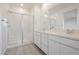 Bathroom with a double sink vanity, large mirror, and glass-enclosed shower at 7777 Vino Vranec Ct, Las Vegas, NV 89113