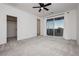 Spacious bedroom with gray carpet, ceiling fan, closet, and sliding glass doors to a balcony at 7777 Vino Vranec Ct, Las Vegas, NV 89113