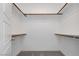 Walk-in closet with carpet and custom built-in shelving with wood support bars at 7777 Vino Vranec Ct, Las Vegas, NV 89113