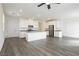 Open-concept kitchen with gray countertops, stainless steel appliances, white cabinetry and modern gray wood flooring at 7777 Vino Vranec Ct, Las Vegas, NV 89113