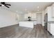 Open concept kitchen with stainless steel appliances, white cabinetry, gray countertop and gray wood flooring throughout at 7777 Vino Vranec Ct, Las Vegas, NV 89113