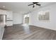 Open floor plan with modern gray wood floors, large windows, and access to a backyard, ideal for entertaining at 7777 Vino Vranec Ct, Las Vegas, NV 89113