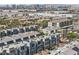 Extended aerial view of a modern residential community with gray townhomes and the city skyline in the background at 8042 Misty Canyon Ave, Las Vegas, NV 89113