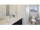Bright bathroom featuring a white countertop, dark cabinets, and a toilet near a window at 8042 Misty Canyon Ave, Las Vegas, NV 89113