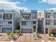 Modern three-story home featuring a gray facade, balcony, roof deck, and a paved driveway with desert landscaping at 8042 Misty Canyon Ave, Las Vegas, NV 89113