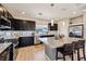 Modern kitchen with black cabinetry, stainless steel appliances, granite countertops, and island with barstool seating at 8042 Misty Canyon Ave, Las Vegas, NV 89113