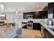 Stylish kitchen featuring stainless steel appliances, dark cabinetry, and an island with a granite countertop at 8042 Misty Canyon Ave, Las Vegas, NV 89113