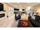Open-concept living area with fireplace, modern furnishings and seamless connection to kitchen and staircase at 8042 Misty Canyon Ave, Las Vegas, NV 89113