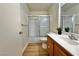 Well-lit bathroom features a shower and tub combination with sliding glass doors and wood-look flooring at 8410 Eldora Ave # 2046, Las Vegas, NV 89117