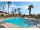 Community swimming pool with palm trees and blue skies on a sunny day, perfect for relaxation and recreation at 8410 Eldora Ave # 2046, Las Vegas, NV 89117