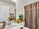 Well-lit bathroom with a single vanity, toilet, and a shower with decorative shower curtain at 8754 Brindisi Park Ave, Las Vegas, NV 89148