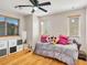 Cozy bedroom featuring hardwood floors, a window with blinds, and ample storage at 8754 Brindisi Park Ave, Las Vegas, NV 89148