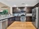 Well-lit kitchen featuring stainless steel appliances, modern countertops and dark wood cabinetry at 8754 Brindisi Park Ave, Las Vegas, NV 89148