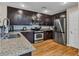 Well-equipped kitchen featuring granite countertops, stainless steel appliances, and dark wood cabinetry at 8754 Brindisi Park Ave, Las Vegas, NV 89148